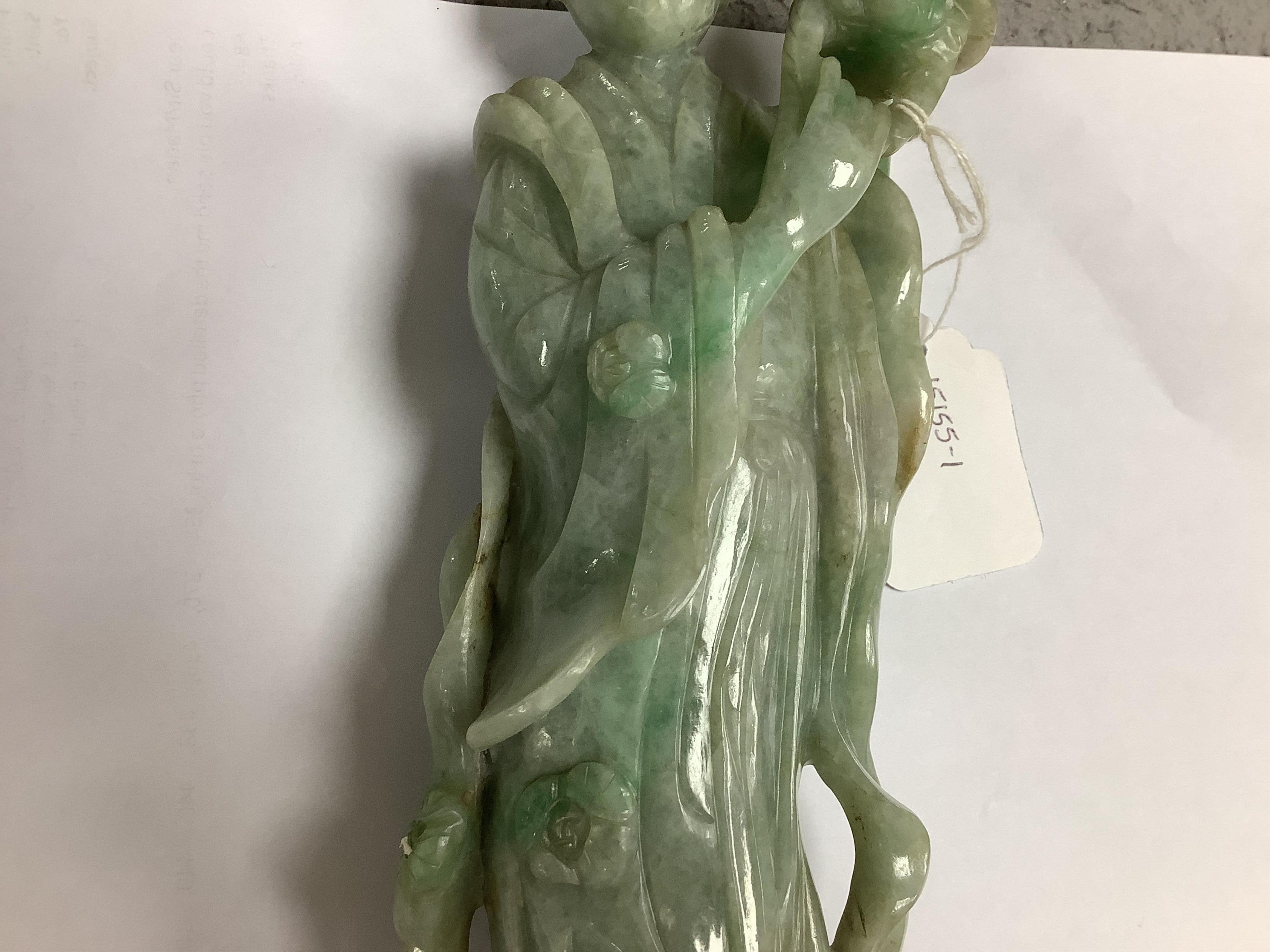 A Chinese jadeite carving of Guanyin, on associated hardwood stand, 38cm high. Condition - fair